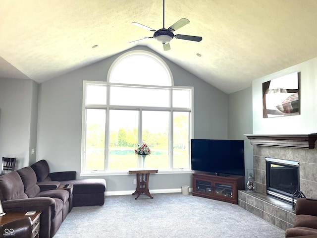 living area featuring lofted ceiling, carpet, a tile fireplace, and baseboards