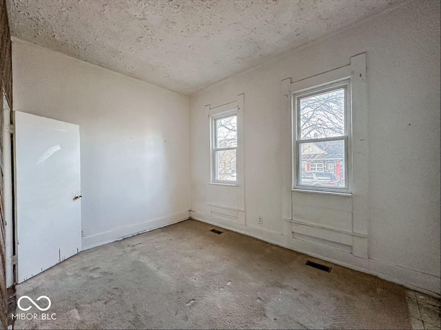 unfurnished room with visible vents and a textured ceiling