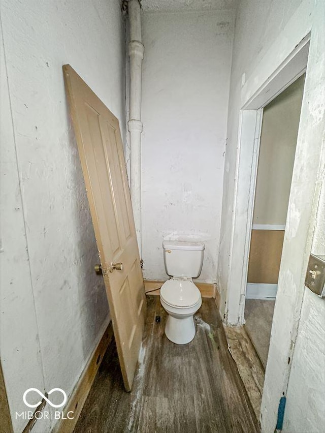 bathroom with toilet and wood finished floors