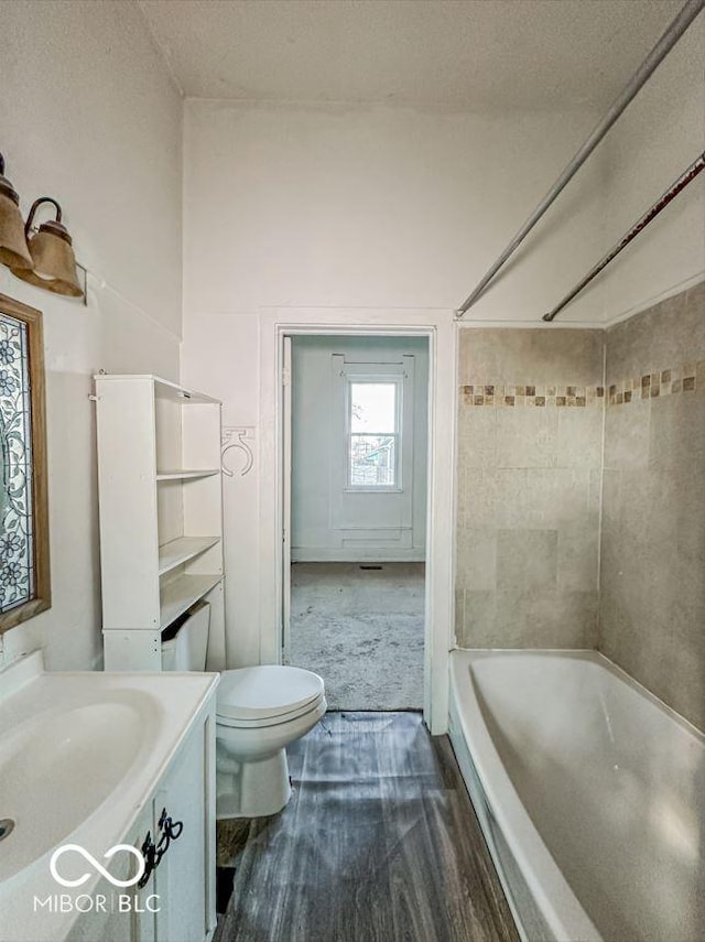 full bathroom featuring toilet, vanity, bathtub / shower combination, and wood finished floors