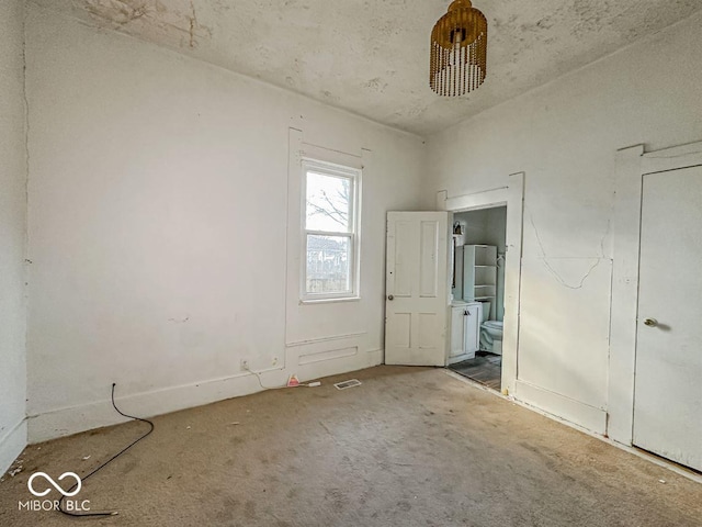 unfurnished bedroom featuring connected bathroom and carpet flooring