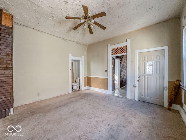 interior space with ceiling fan, carpet floors, and a textured ceiling