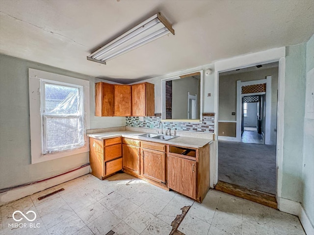 kitchen featuring light floors, visible vents, a sink, light countertops, and tasteful backsplash