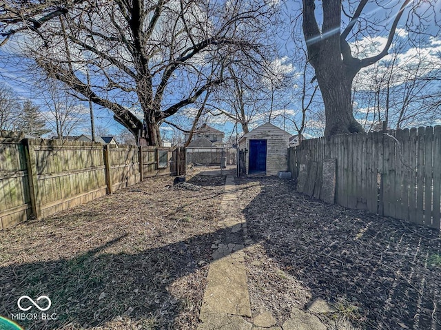 view of yard featuring a fenced backyard, an outdoor structure, and a shed