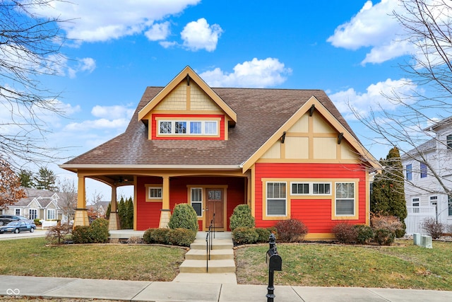 view of front facade featuring a porch, a front lawn, and roof with shingles