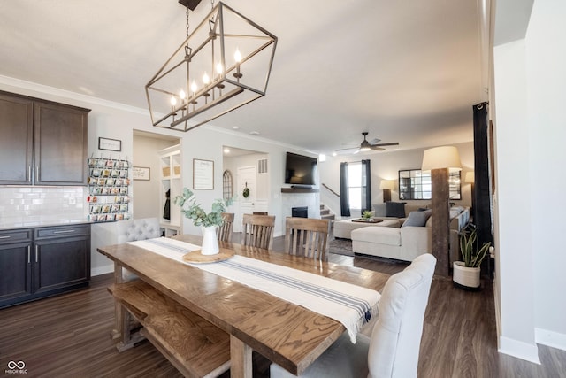 dining space with baseboards, ceiling fan, dark wood finished floors, and crown molding