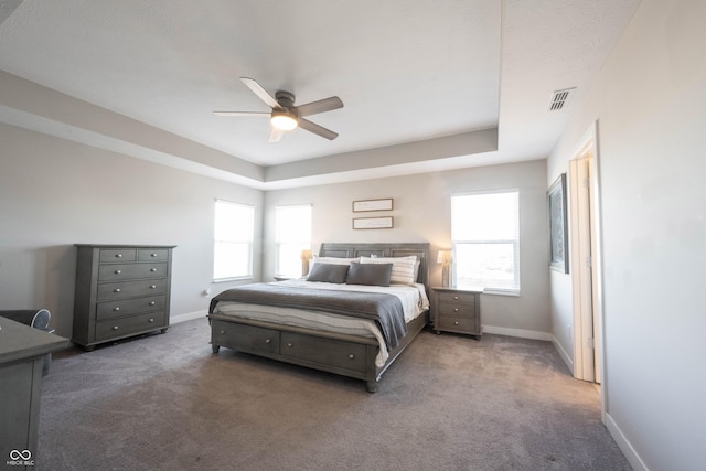 carpeted bedroom with visible vents, baseboards, and ceiling fan