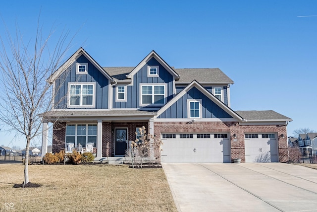 craftsman inspired home featuring a front yard, covered porch, concrete driveway, board and batten siding, and brick siding