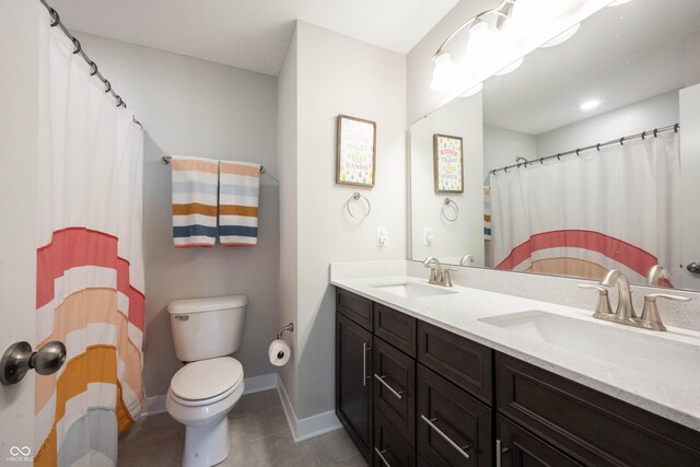 bathroom featuring a sink, toilet, double vanity, and tile patterned floors