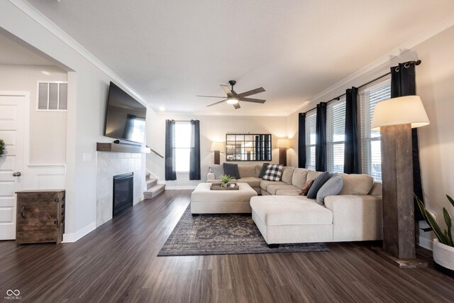 living room featuring visible vents, dark wood finished floors, a fireplace, and ornamental molding