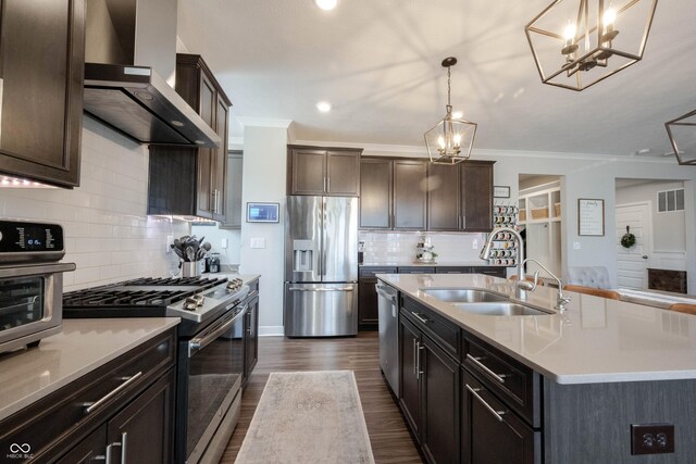 kitchen featuring visible vents, a sink, appliances with stainless steel finishes, wall chimney exhaust hood, and light countertops