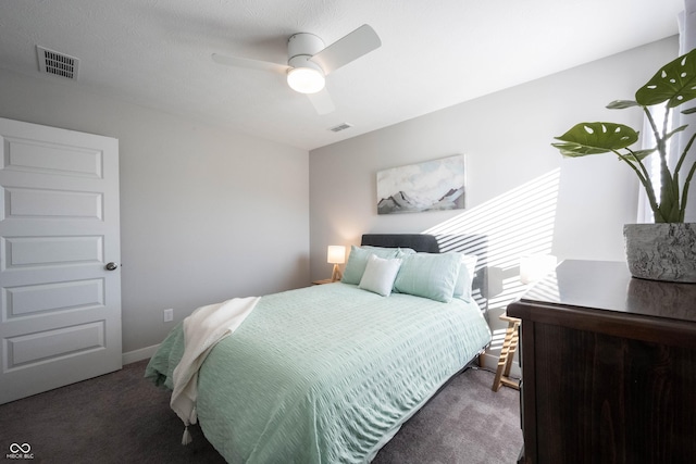 carpeted bedroom with visible vents, baseboards, and a ceiling fan