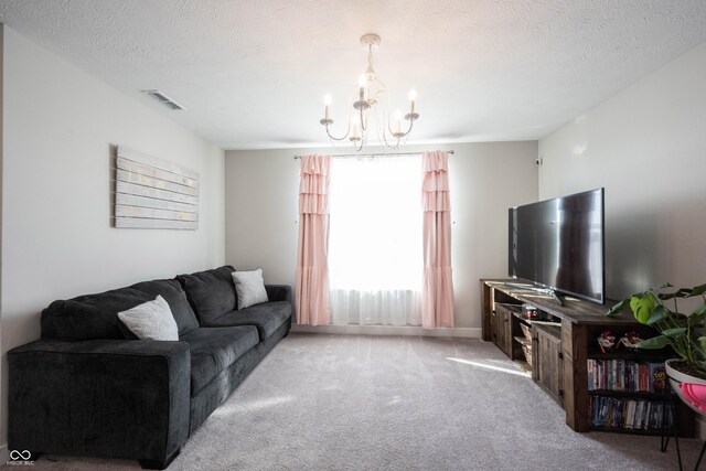 living area with a textured ceiling, carpet, visible vents, and a chandelier