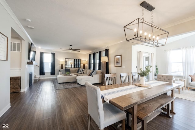 dining space with a wealth of natural light, dark wood-style floors, and crown molding