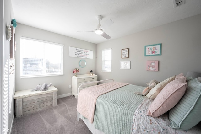 bedroom featuring visible vents, baseboards, light colored carpet, and ceiling fan