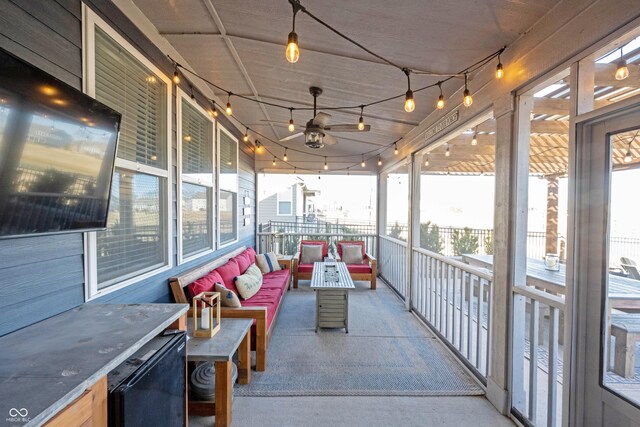 sunroom / solarium featuring rail lighting and a ceiling fan