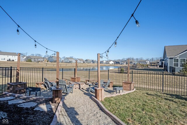 view of yard featuring a residential view, a fire pit, a patio, and fence