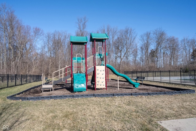 community jungle gym with a lawn and fence