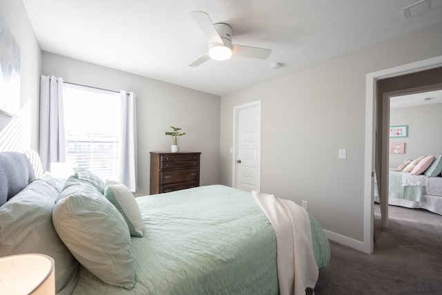 bedroom with a ceiling fan, visible vents, baseboards, and carpet floors