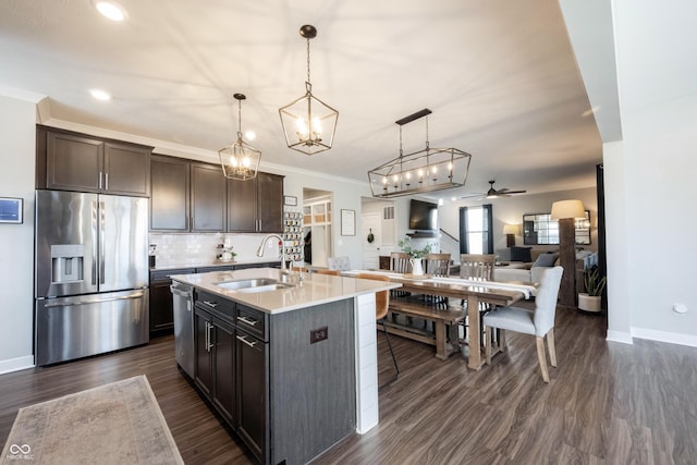 kitchen with a sink, stainless steel appliances, dark brown cabinetry, light countertops, and backsplash