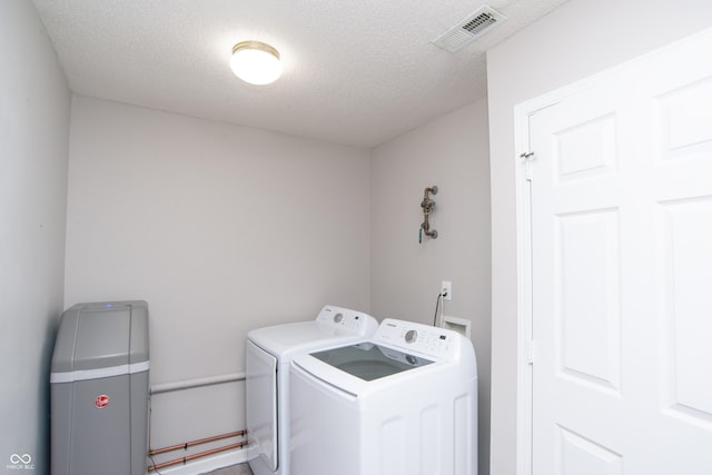 laundry area with a textured ceiling, laundry area, visible vents, and washer and dryer