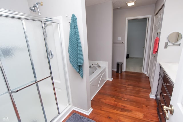 full bathroom featuring vanity, wood finished floors, a shower stall, and a bath