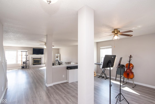 interior space with a textured ceiling, baseboards, and wood finished floors