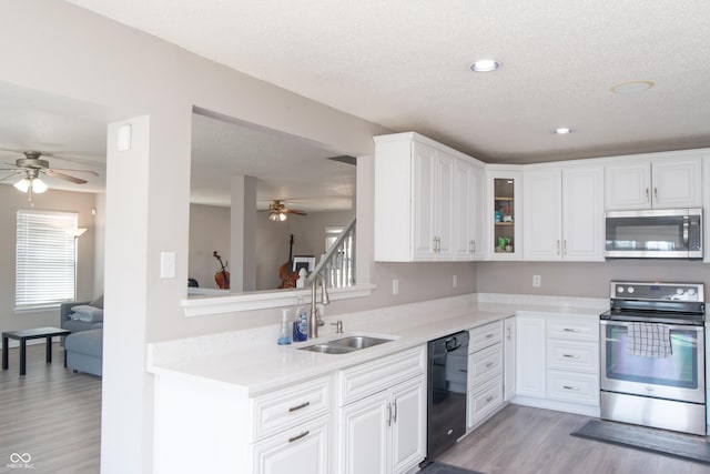 kitchen featuring light wood-style flooring, appliances with stainless steel finishes, light countertops, and a sink