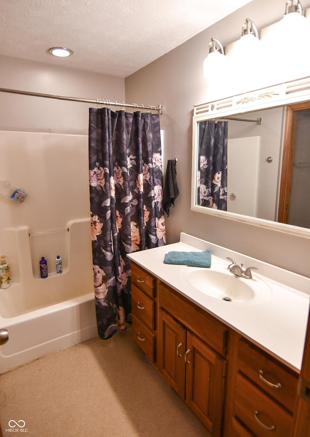 bathroom featuring shower / bath combo, a textured ceiling, and vanity