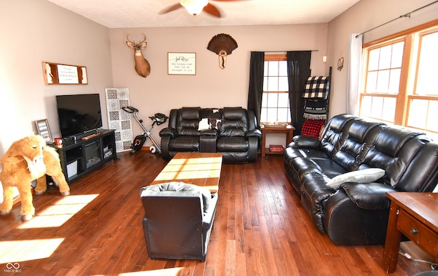 living area featuring a ceiling fan, dark wood-style flooring, and plenty of natural light