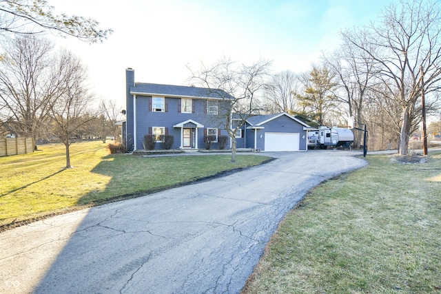 colonial house with a front lawn, a chimney, an attached garage, and aphalt driveway