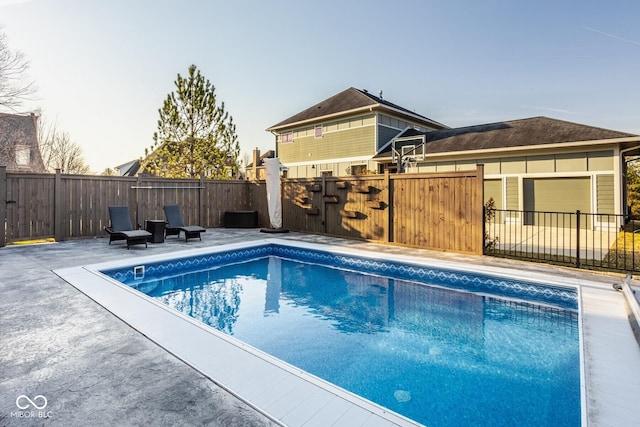 view of pool with a patio area, a fenced in pool, and fence