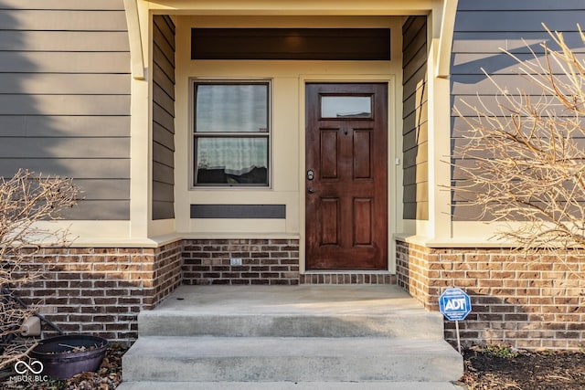 property entrance featuring brick siding