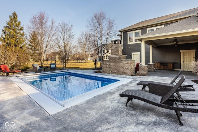 view of swimming pool featuring a patio area, a fenced in pool, and a ceiling fan