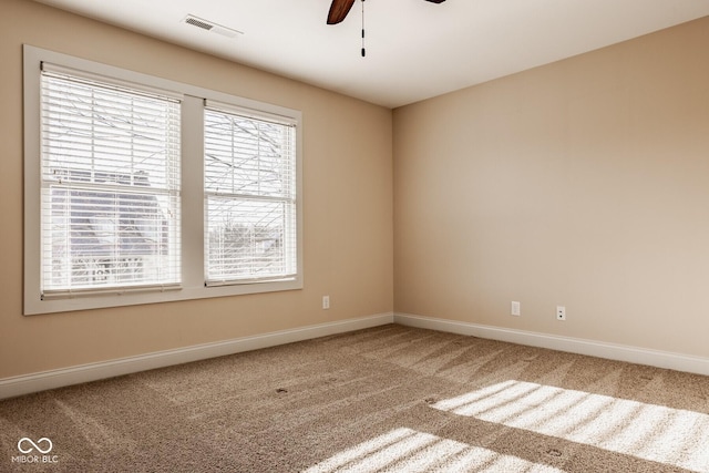 spare room featuring visible vents, a ceiling fan, baseboards, and carpet floors