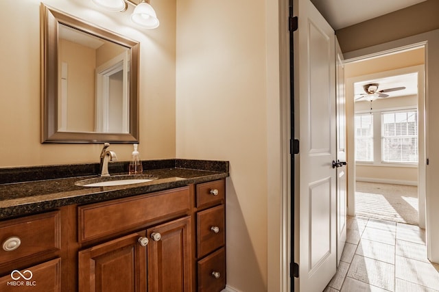 bathroom featuring baseboards, ceiling fan, and vanity