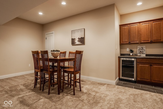 dining space featuring beverage cooler, dark carpet, recessed lighting, a bar, and baseboards