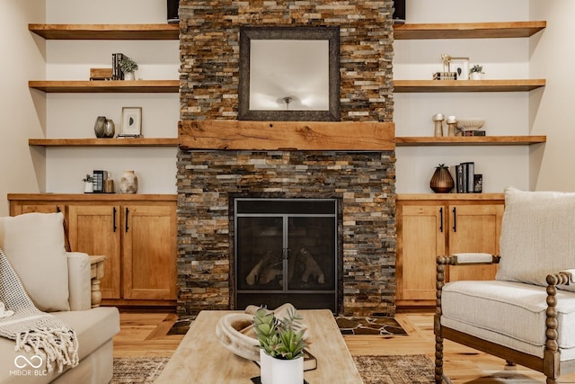 living area with light wood-style flooring and a fireplace