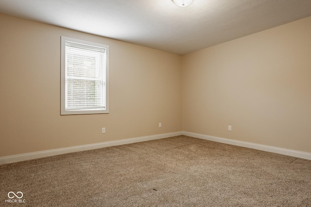 carpeted empty room with baseboards