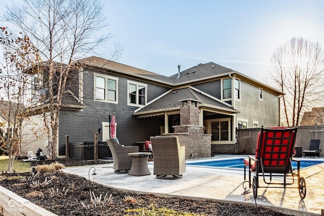 rear view of property featuring a patio area, a fenced in pool, and fence