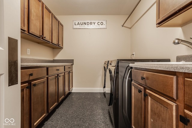 laundry room featuring washer and clothes dryer, cabinet space, and baseboards