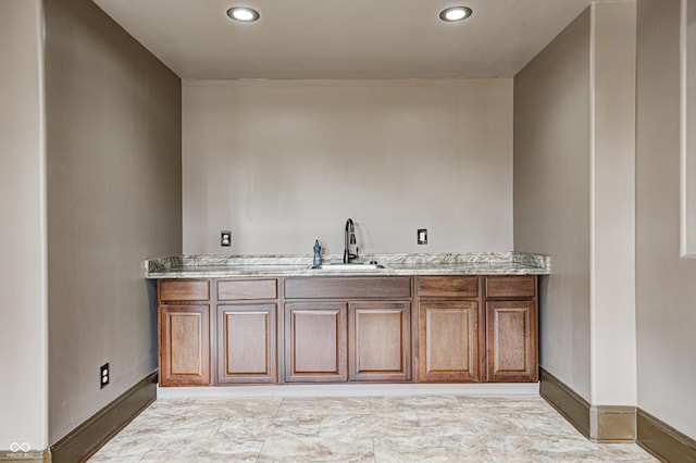 bathroom with recessed lighting, baseboards, and a sink