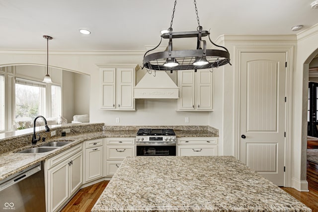 kitchen with arched walkways, a sink, stainless steel appliances, dark wood-type flooring, and custom range hood