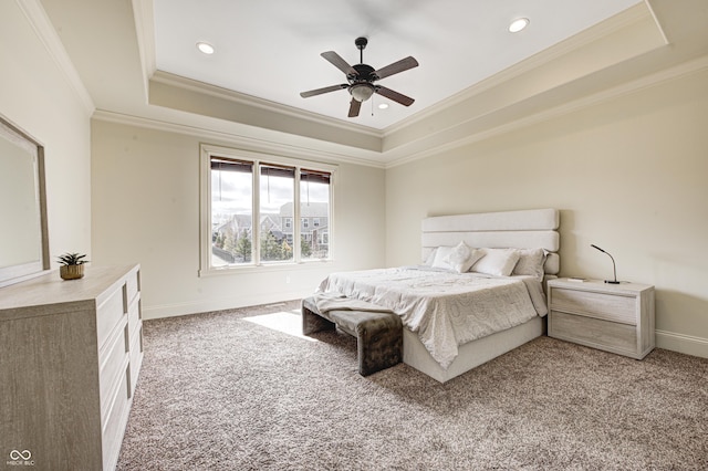 carpeted bedroom with a raised ceiling, recessed lighting, baseboards, and ornamental molding