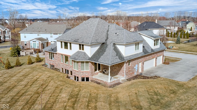 exterior space featuring a yard, a residential view, a garage, and a shingled roof