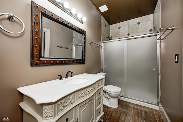 full bath with vanity, a shower stall, toilet, and wood finished floors