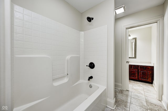 bathroom with tile patterned floors, baseboards, vanity, and  shower combination