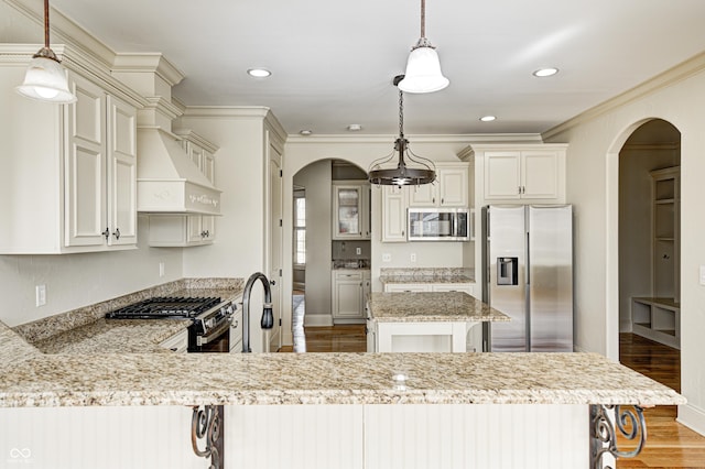 kitchen with arched walkways, light wood-style flooring, stainless steel appliances, and crown molding