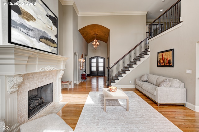 living area featuring baseboards, wood finished floors, stairs, and ornamental molding