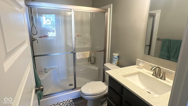 full bathroom featuring a shower stall, toilet, and vanity